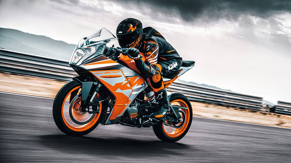 Ktm Rc 200 With Cyclist Background