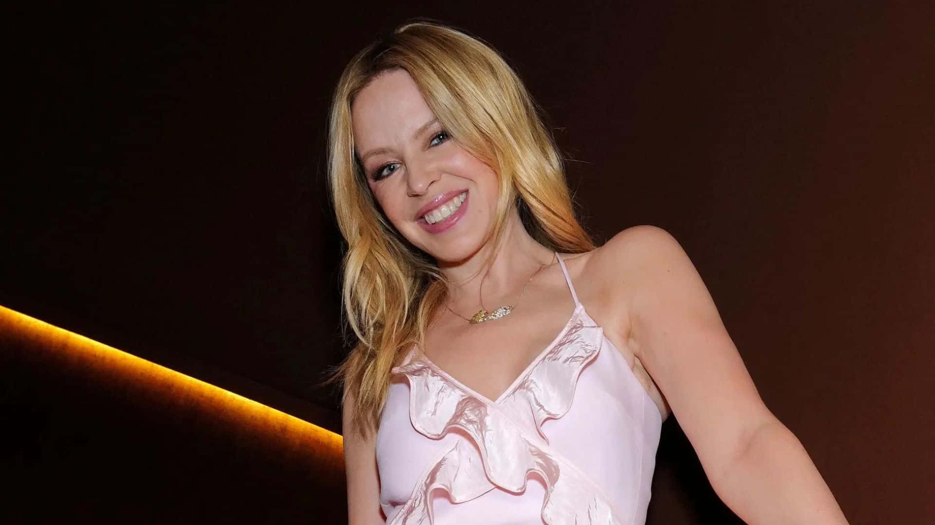 Kylie Minogue Smilingin Pink Top Background