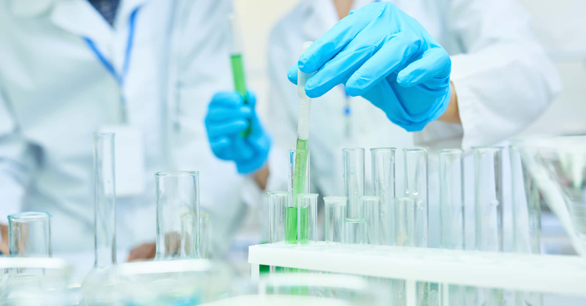 Laboratory Tubes With Green Liquid Background