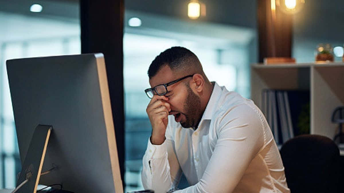 Lackadaisical Worker Lounging At The Office Desk Background