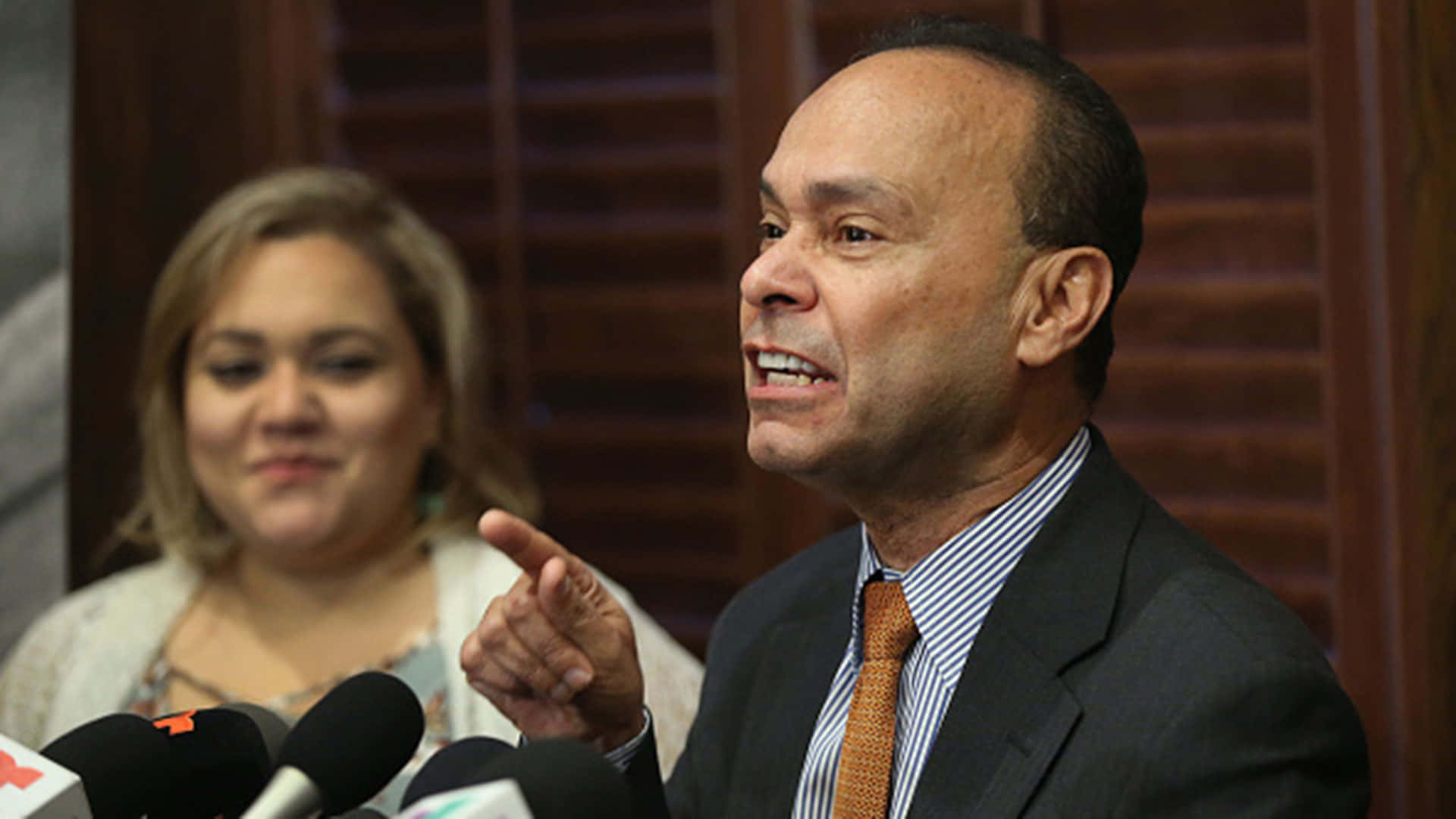 Lady Attentively Listening To Luis Gutiérrez Background