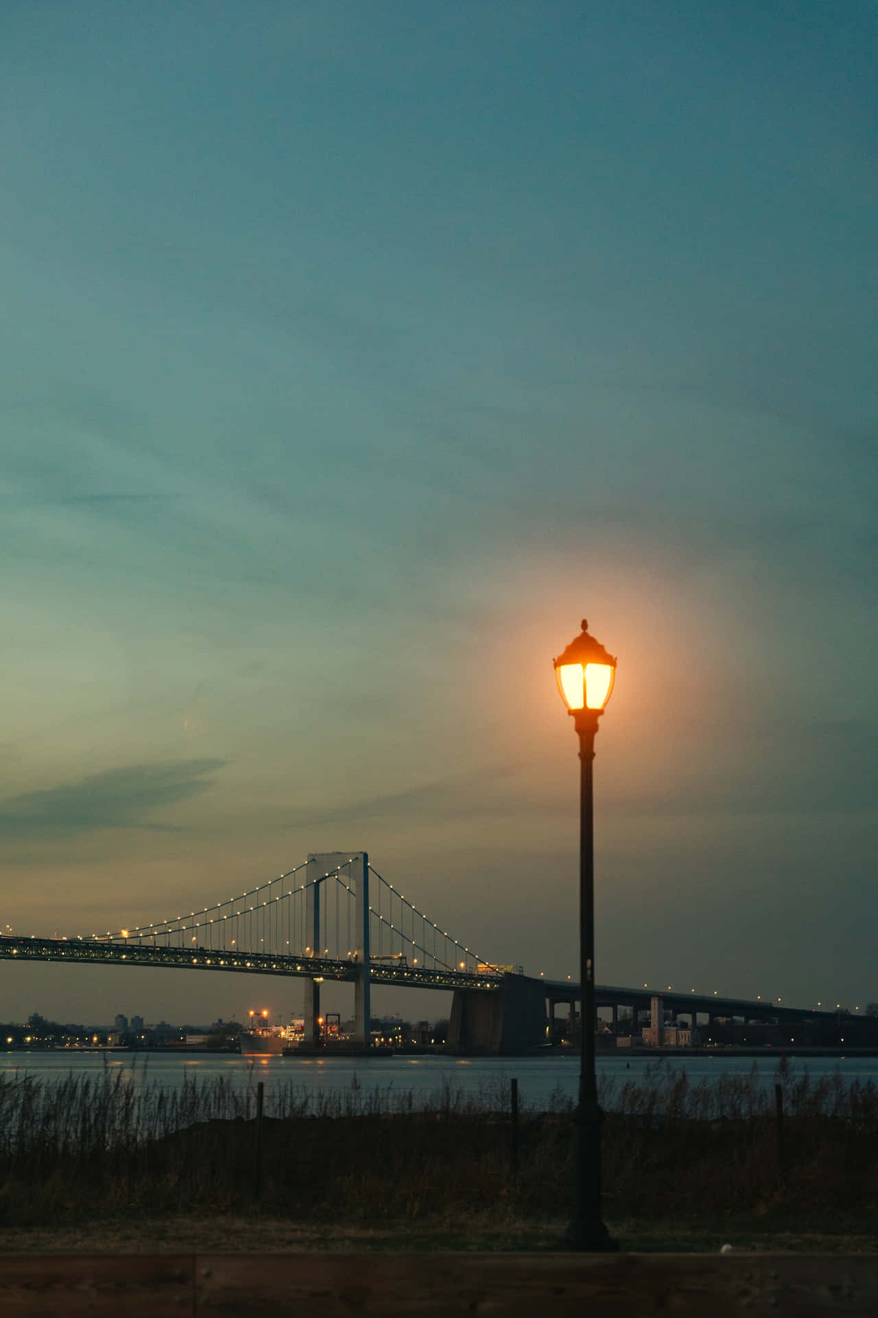 Lamp Post And Bridge Under Evening Sky Background