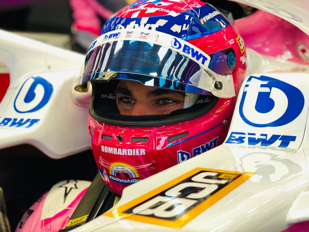 Lance Stroll Donning A Pink Racing Helmet Background