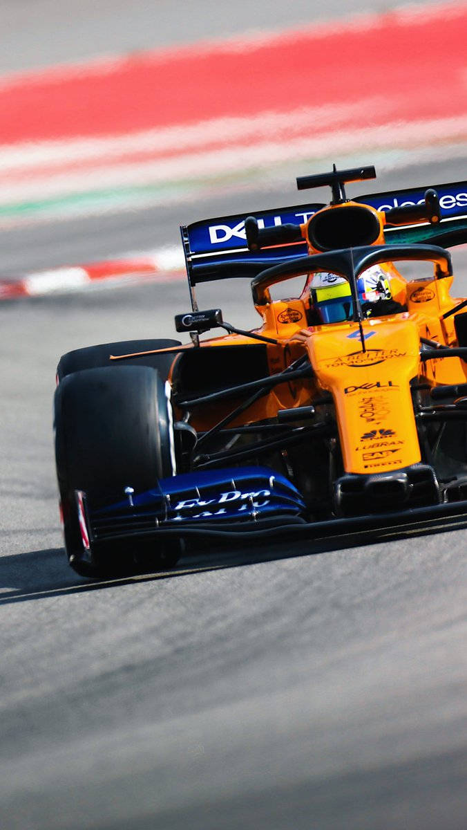 Lando Norris Masterfully Swerving His Racing Car On Track Background