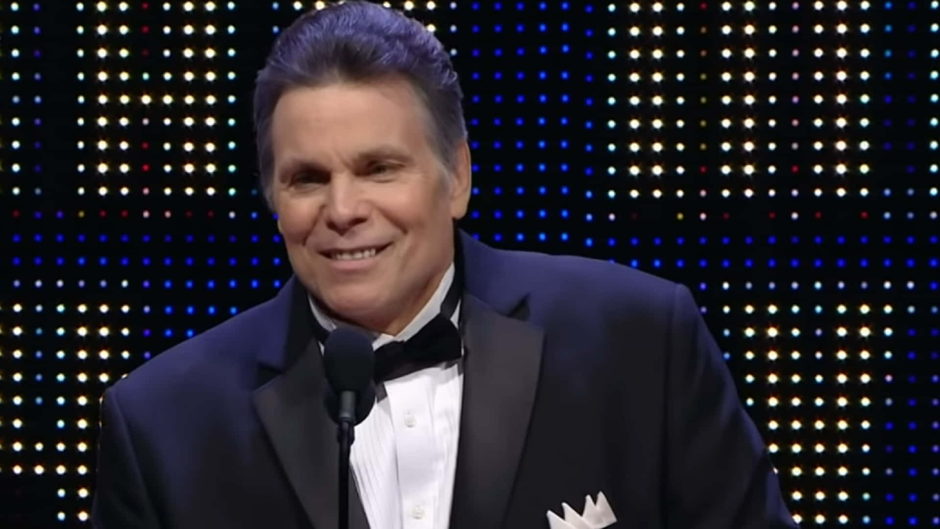 Lanny Poffo Smiling In Black Suit Background