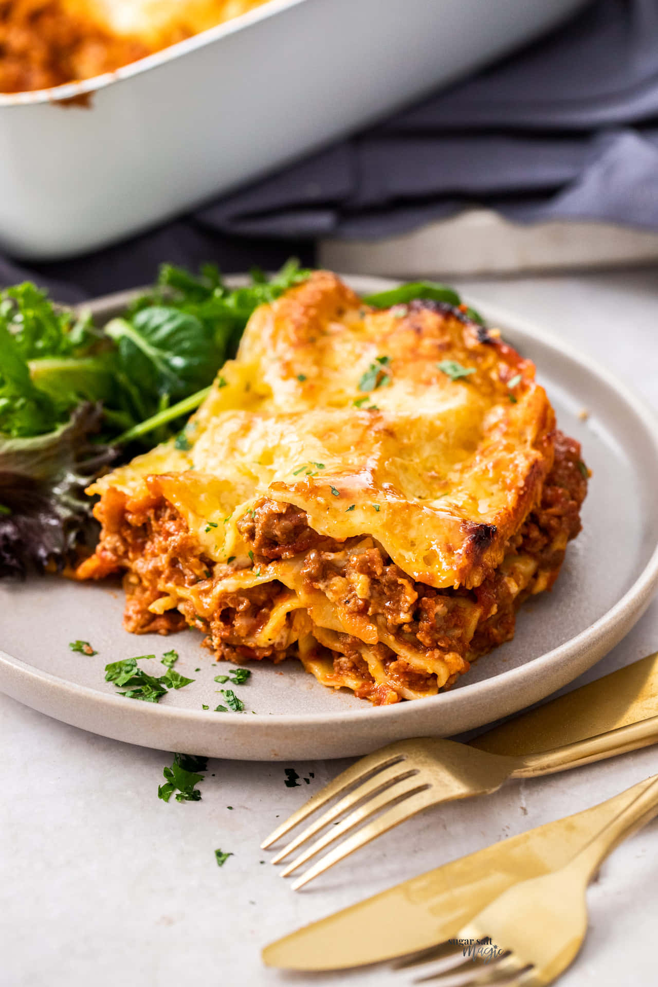 Lasagna Alla Bolognese With Gold Cutlery Background