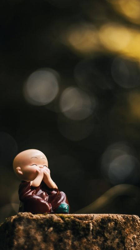 Laughing Buddha On A Tree Stump Background