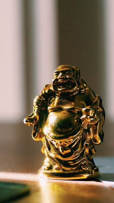 Laughing Buddha On Desk Background