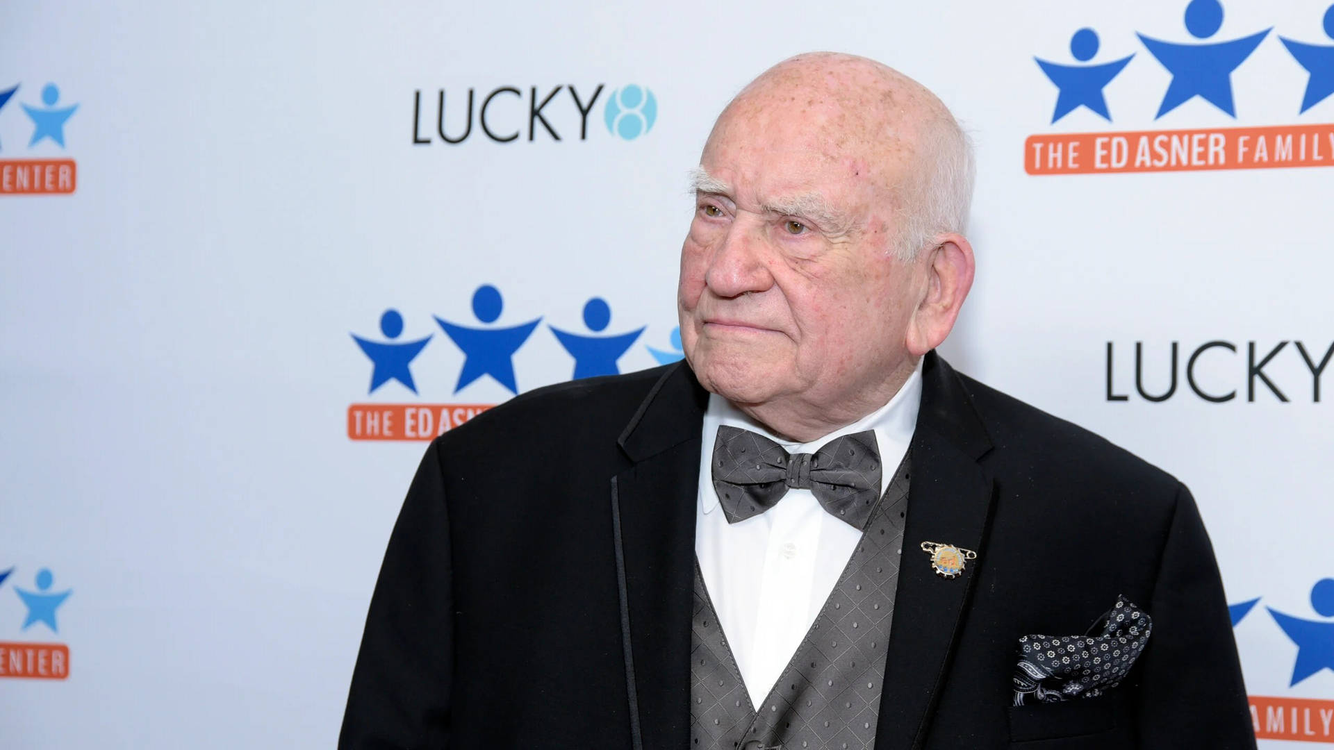 Legendary Actor Edward Asner Against A Blue And White Background Background