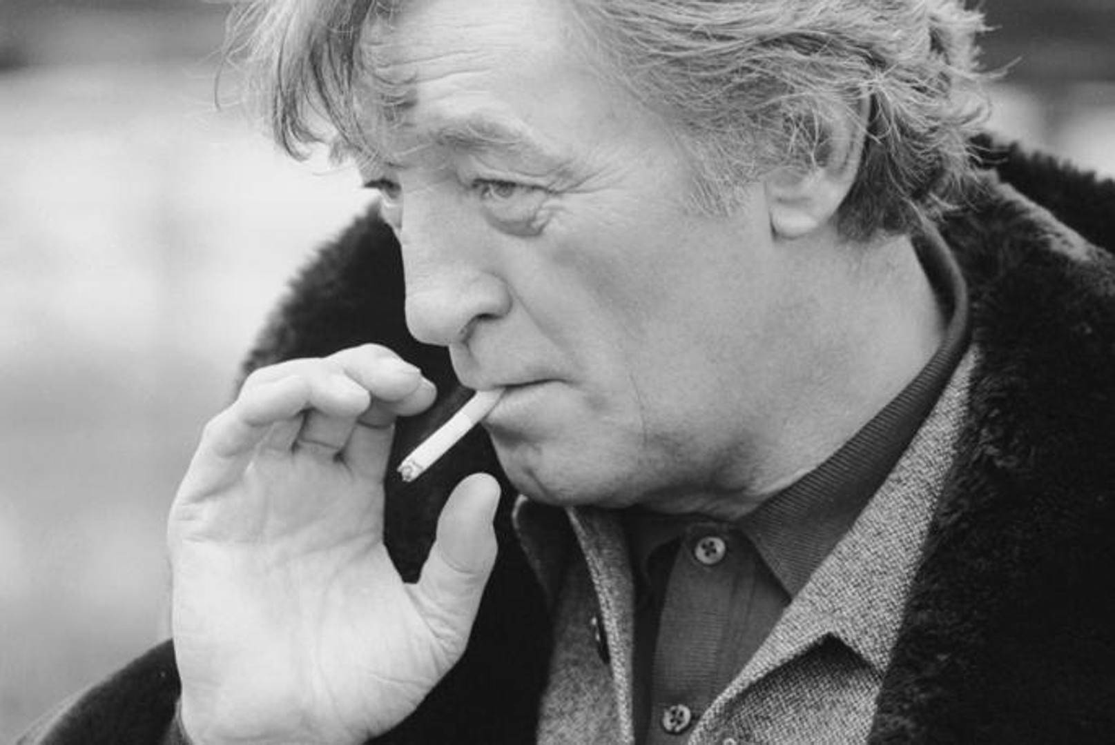 Legendary Actor Robert Mitchum Captured With A Cigarette Background