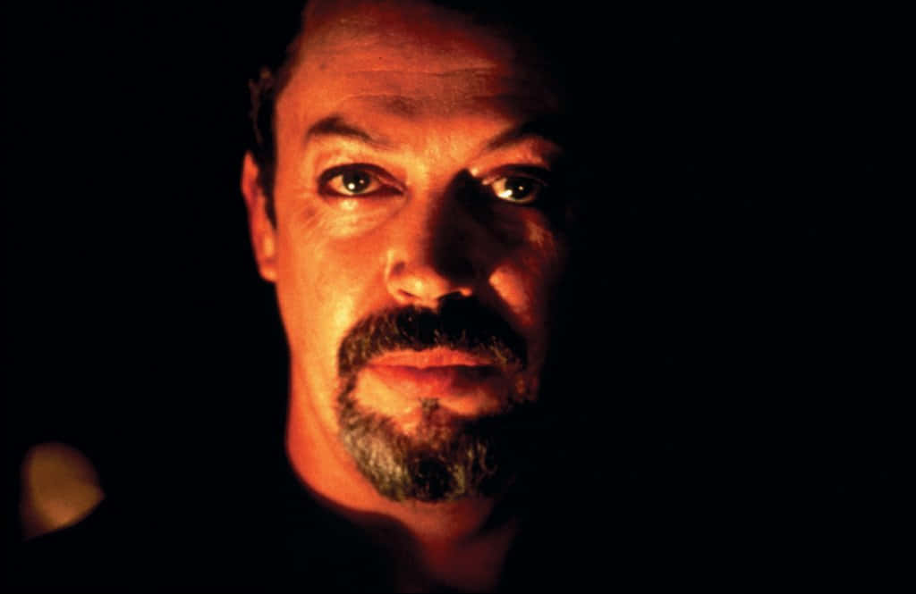 Legendary Actor Tim Curry On Stage Background