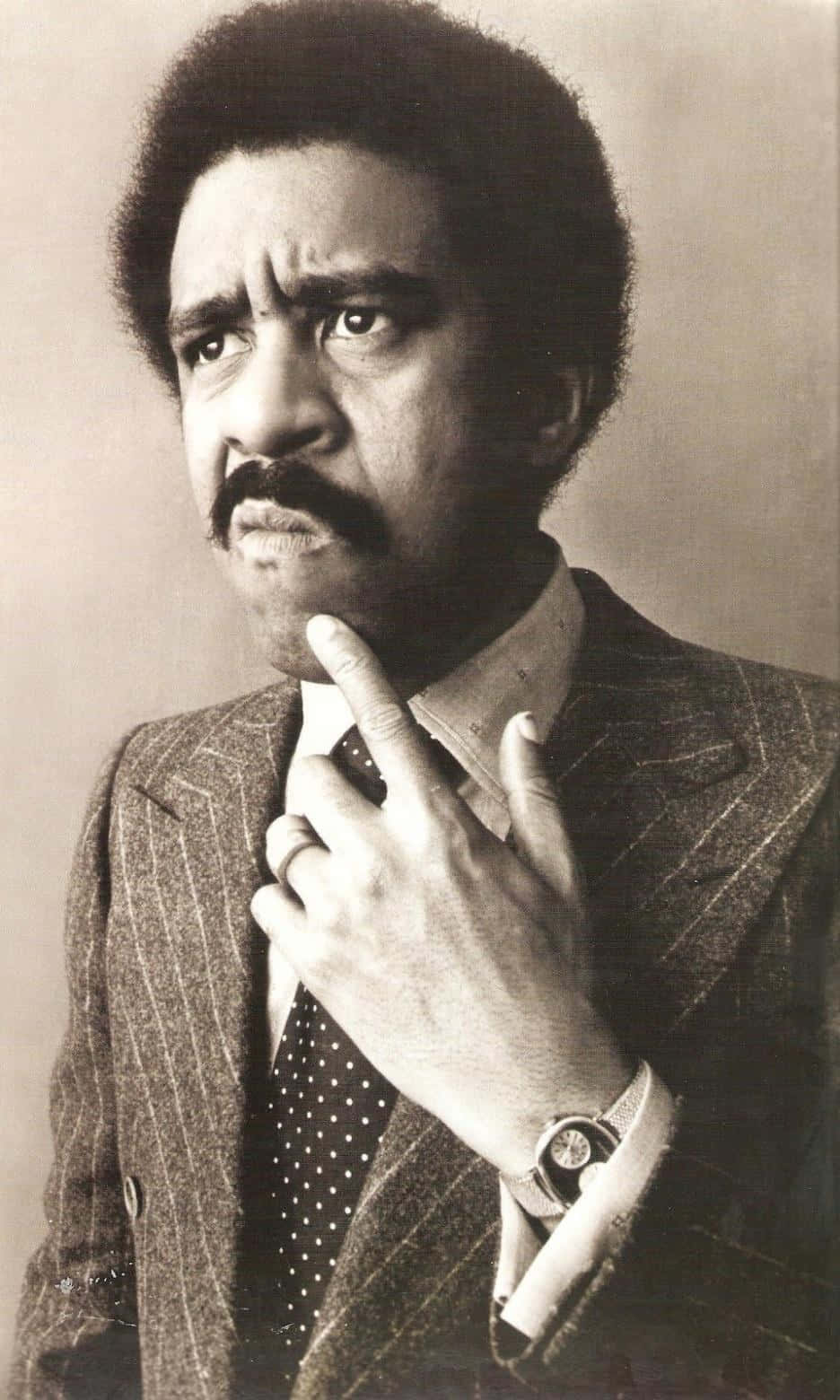 Legendary Comedian Richard Pryor Holding A Mic On Stage Background