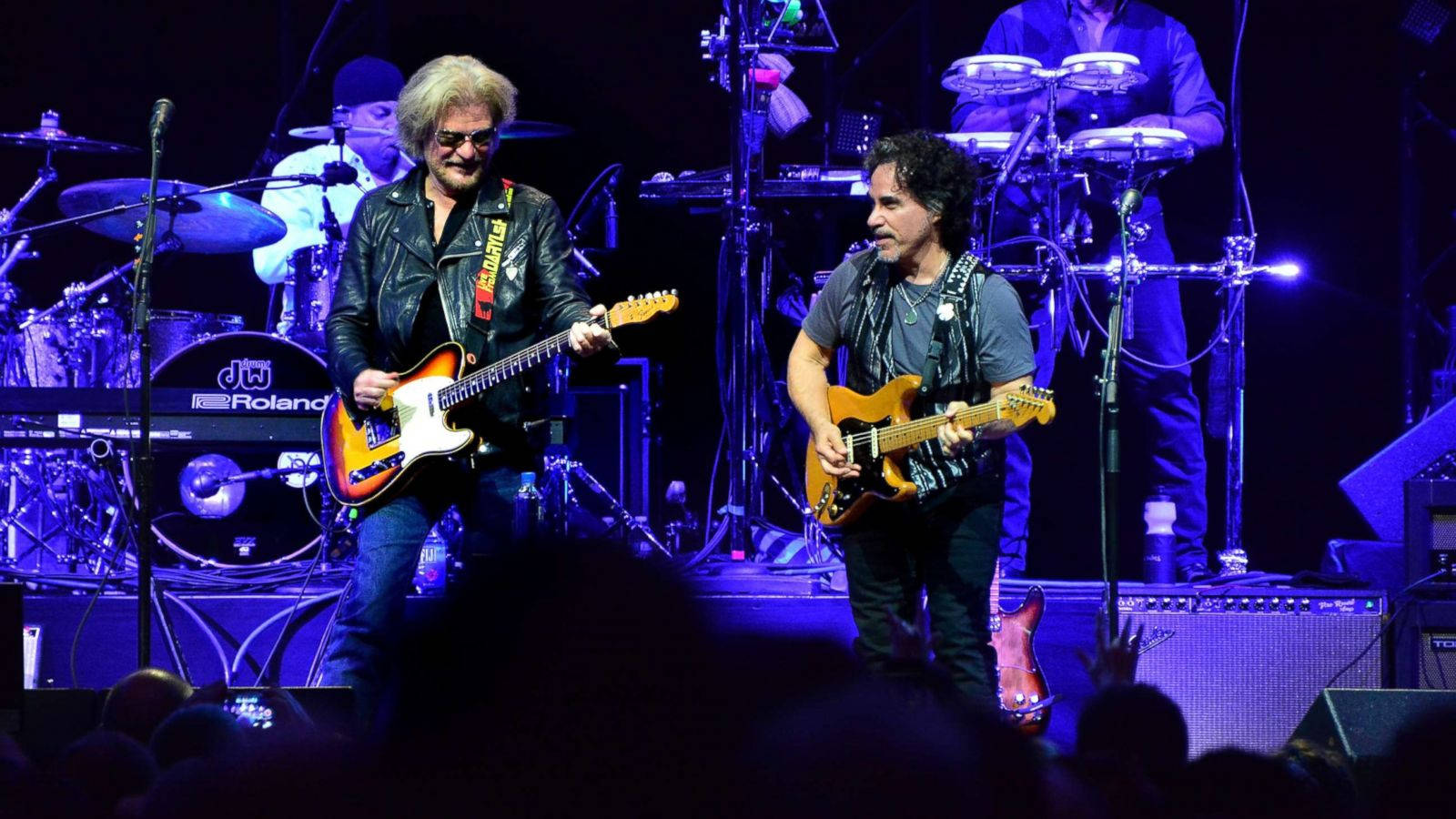 Legendary Duo Daryl Hall And John Oates Performing At A Concert Background