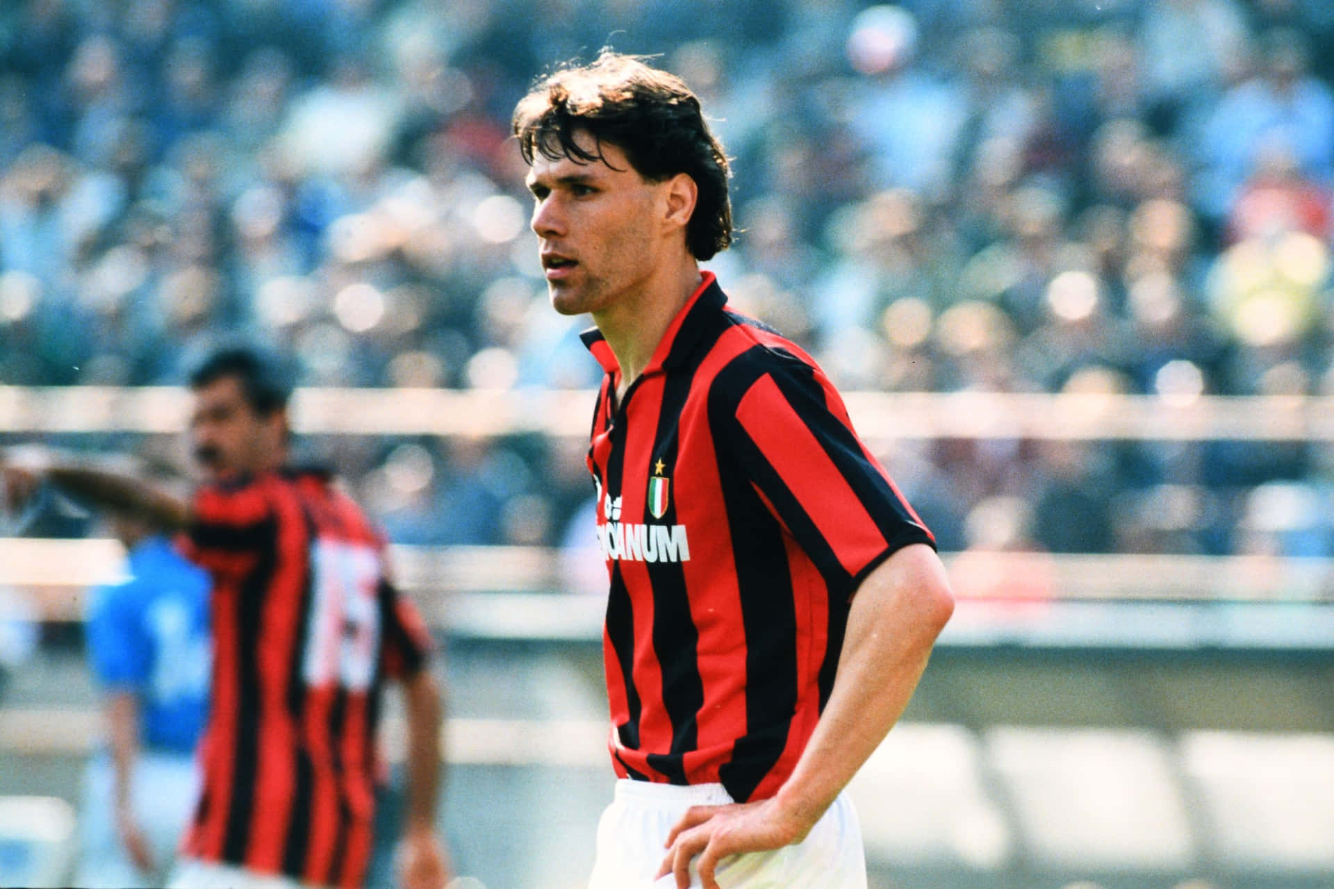 Legendary Footballer Marco Van Basten In A Striped Polo And Shorts Background