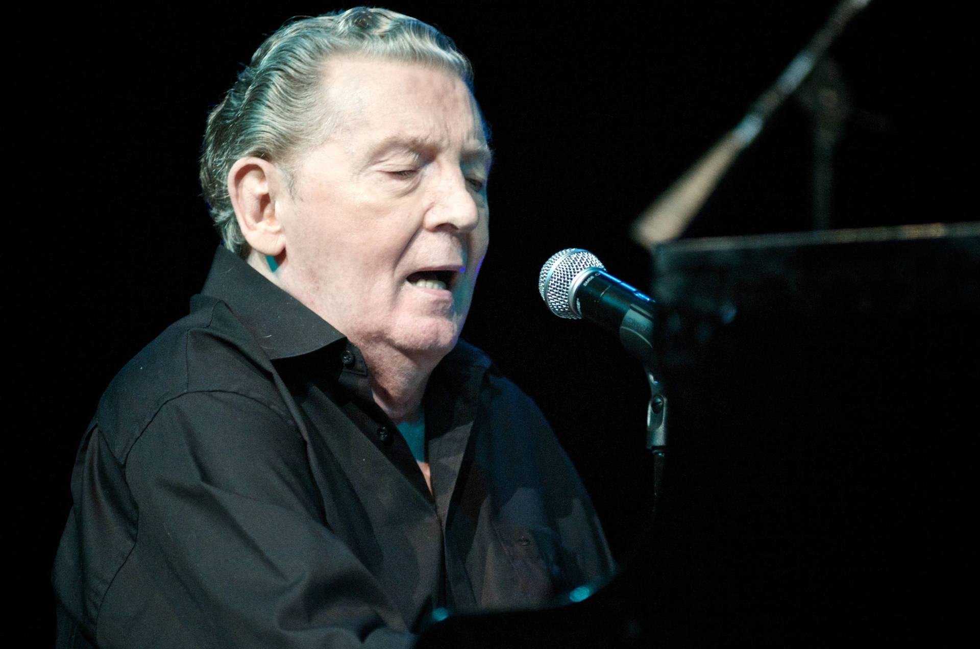 Legendary Music Icon, Jerry Lee Lewis Performing On Stage Background