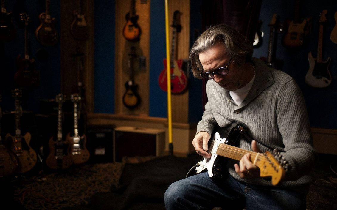 Legendary Musician Eric Clapton In His Guitar Collection Room Background