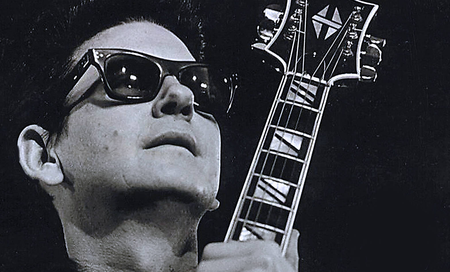 Legendary Musician Roy Orbison Strumming His Guitar Background