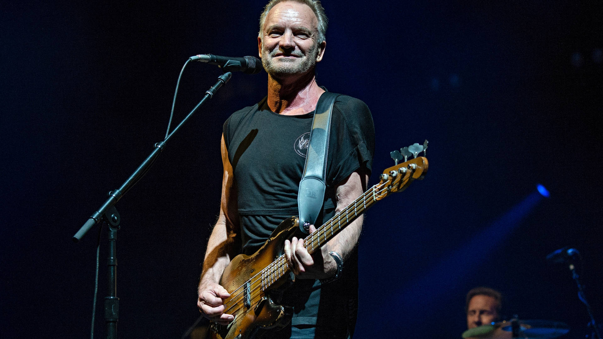 Legendary Musician Sting Wearing A Radiant Smile Background