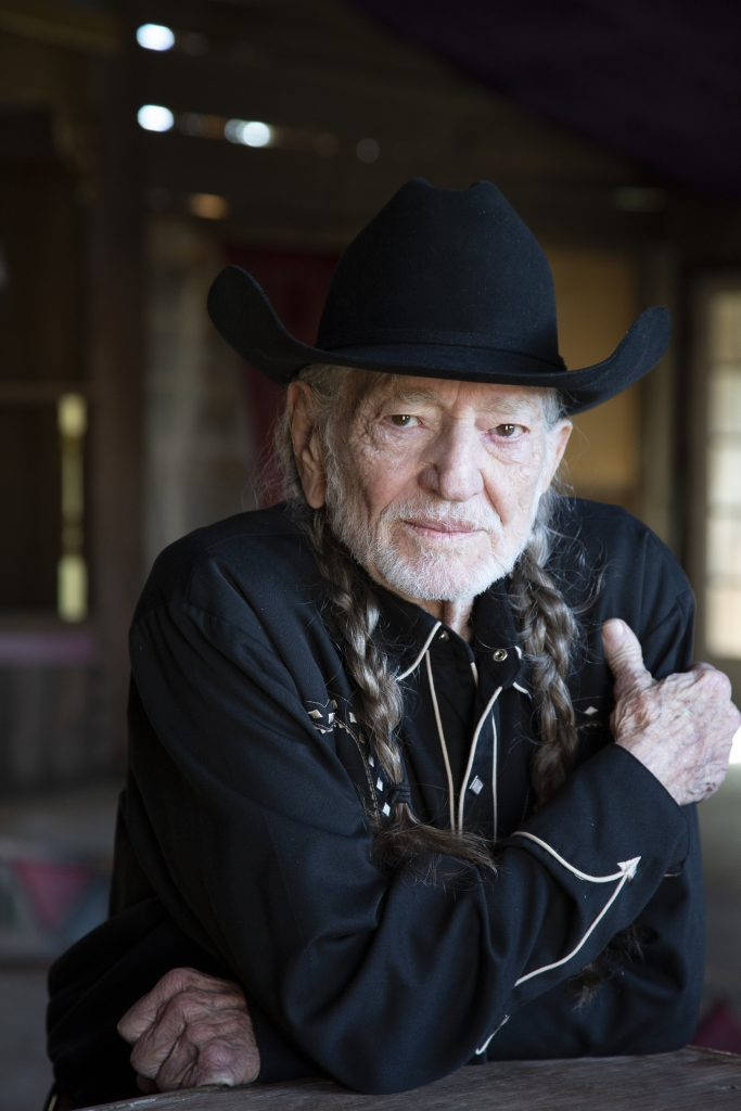 Legendary Musician Willie Nelson In Classic Black Attire Background