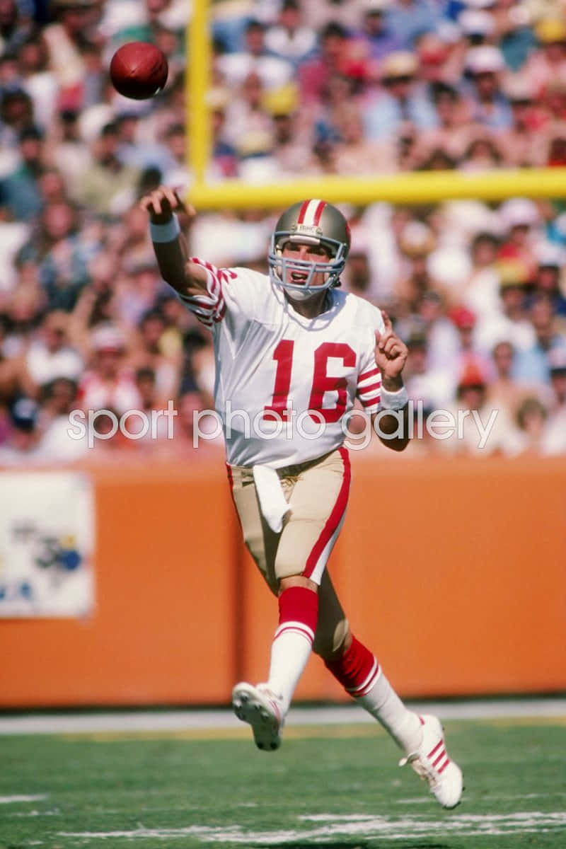 Legendary Nfl Quarterback Joe Montana Throwing A Touchdown Pass Background