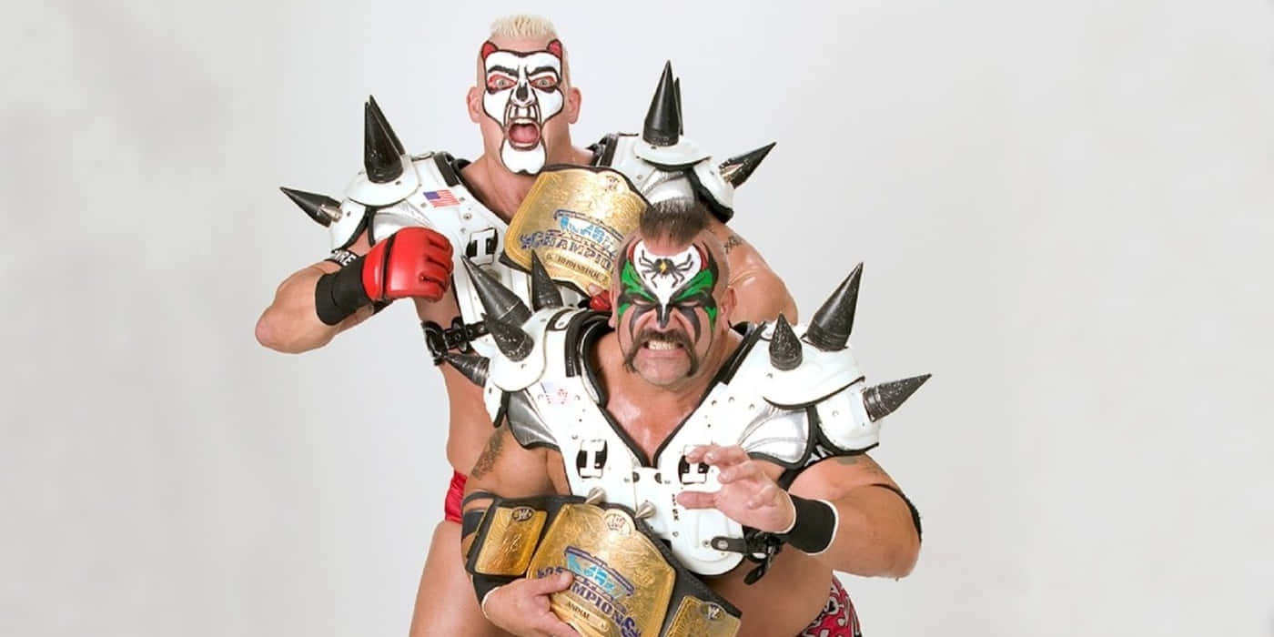 Legendary_ Tag_ Team_ Wrestlers_with_ Championship_ Belts Background