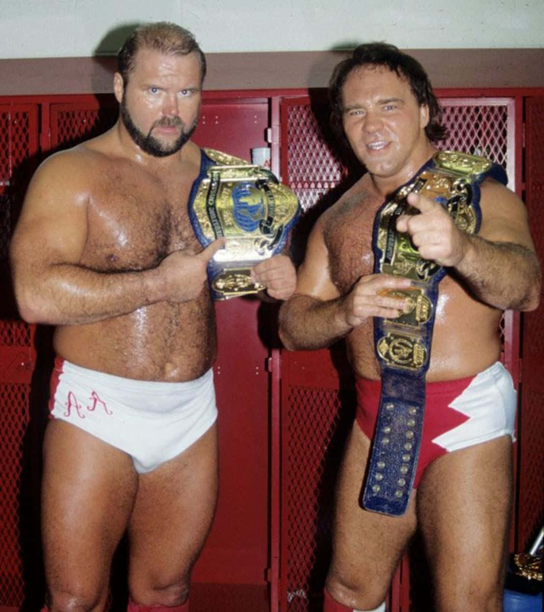 Legendary Wrestlers Larry Zbyszko And Arn Anderson Holding Championship Belts. Background
