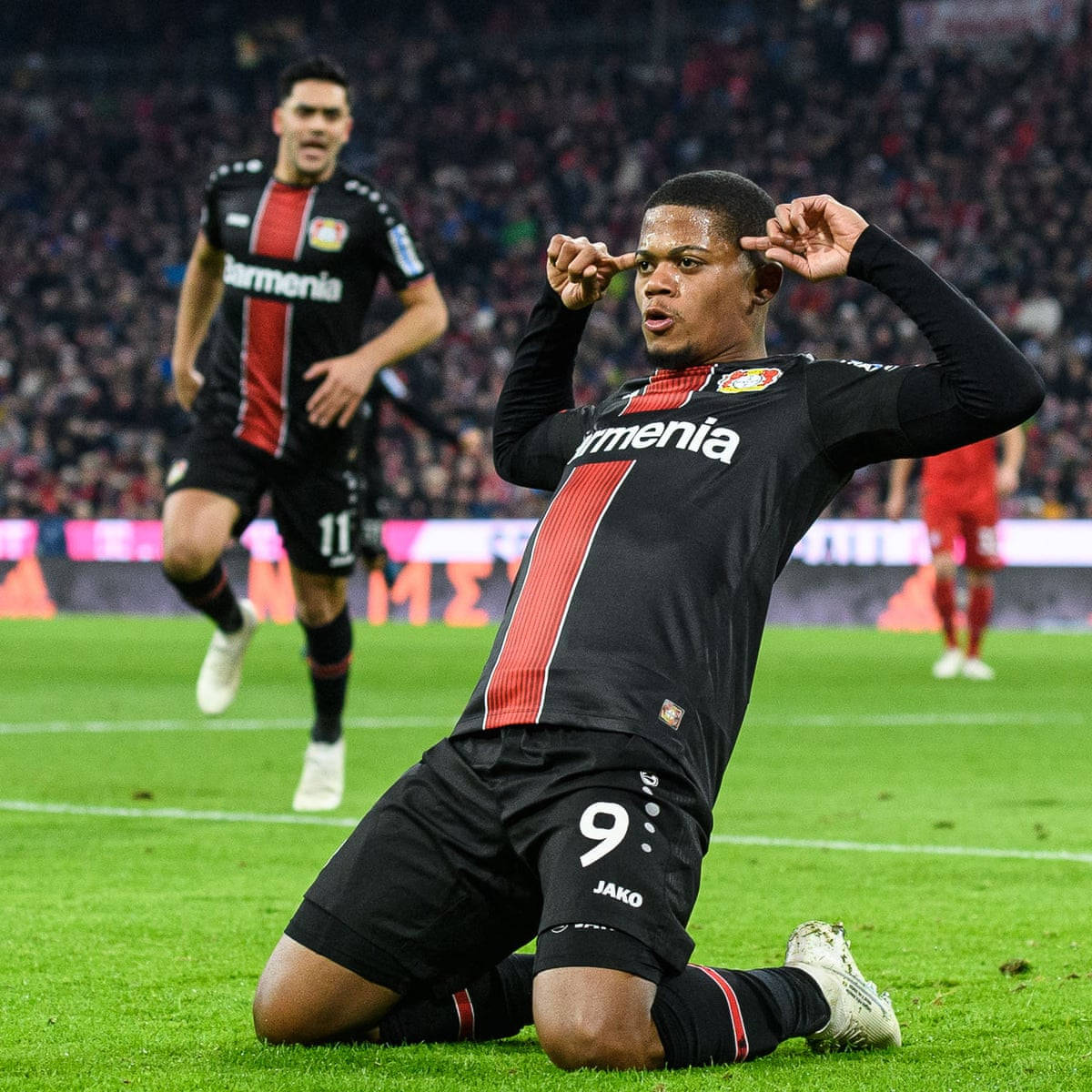 Leon Bailey Kneeling On Ground Background