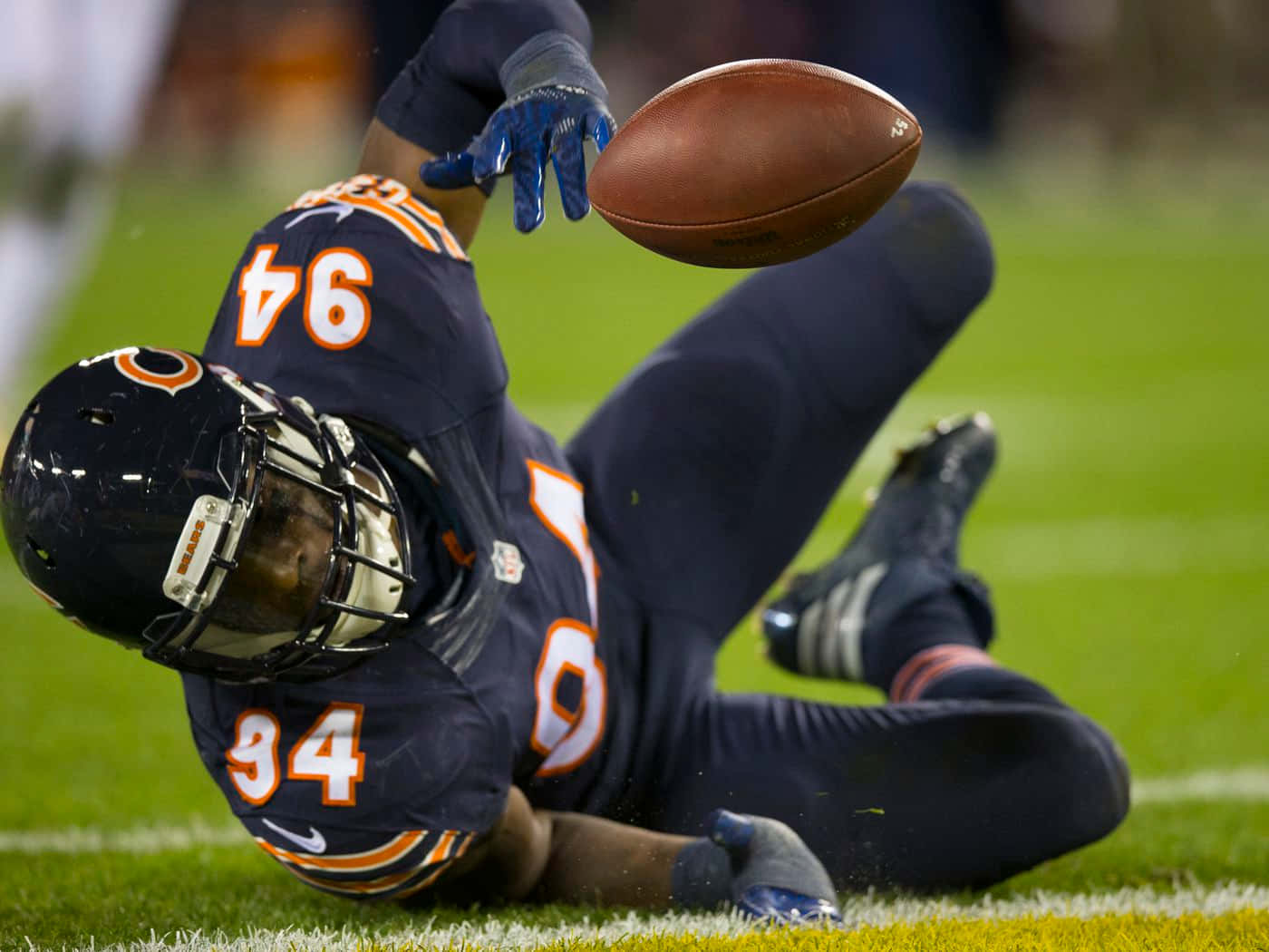 Leonard Floyd Tackling Football On The Ground Background