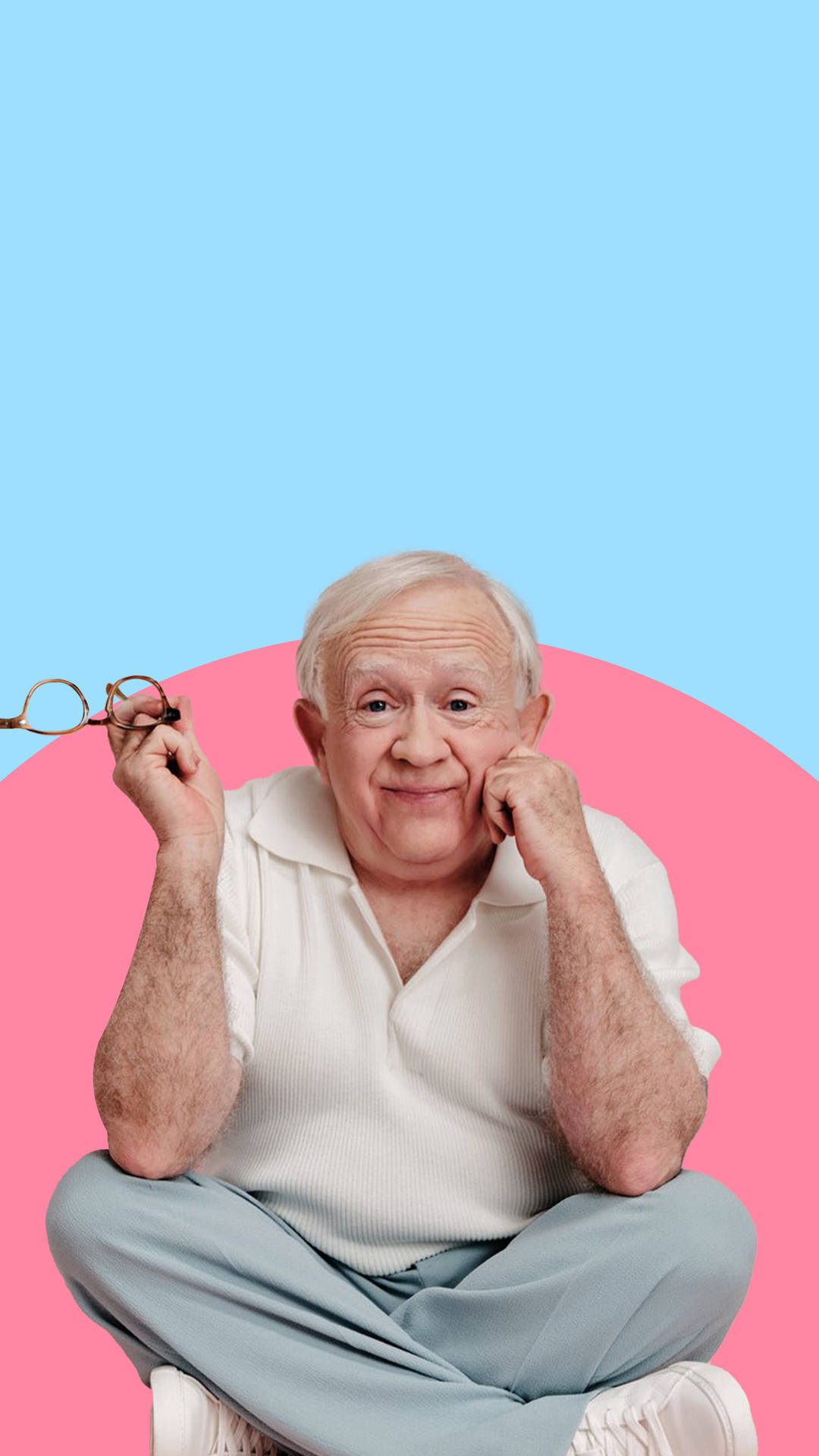 Leslie Jordan Holding Glasses Blue Pink Background