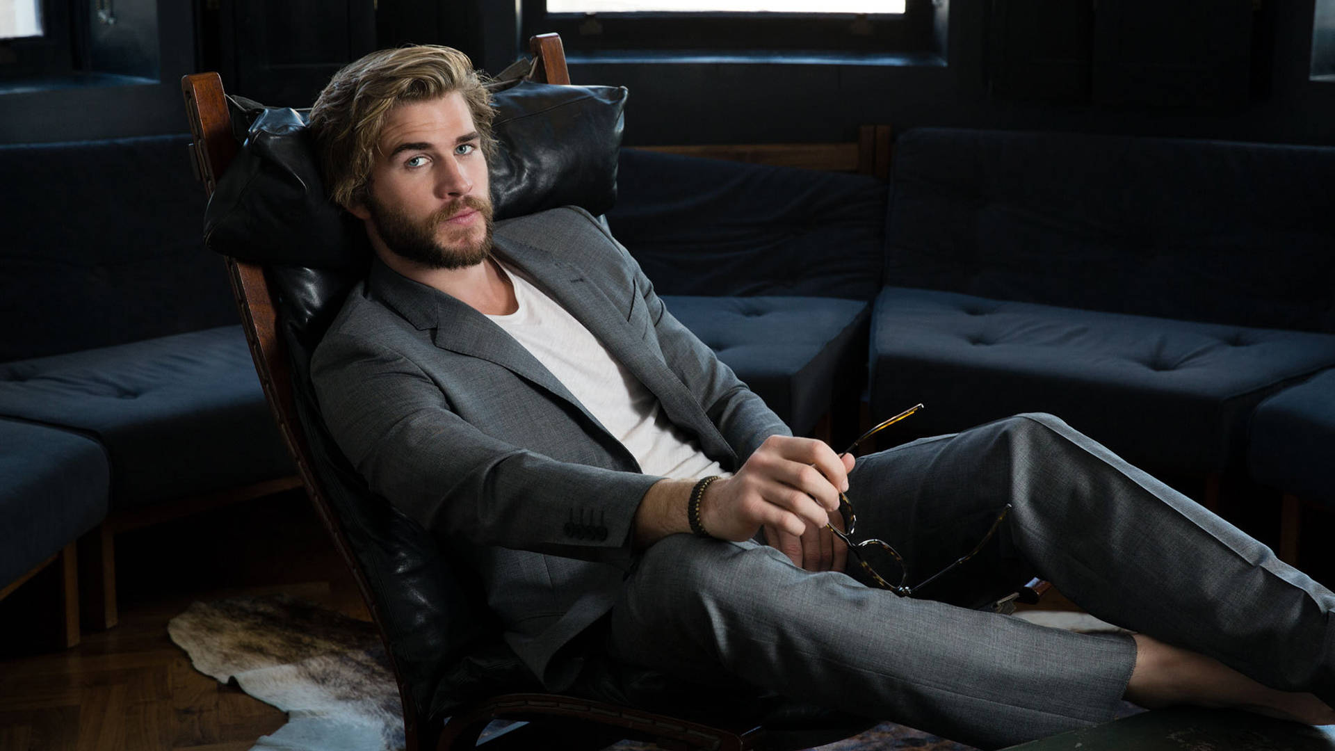 Liam Hemsworth Sitting On Black Couch