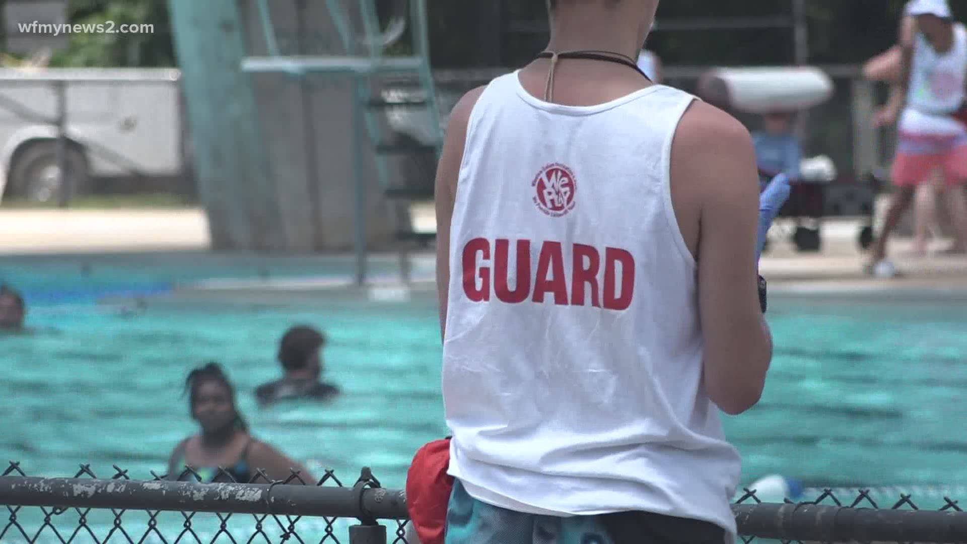 Lifeguard Vigilantly Overseeing A Swimming Pool Background