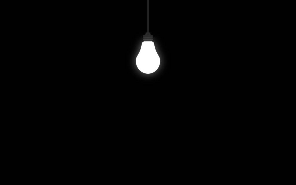 Light Bulb In Solid Black Room Background