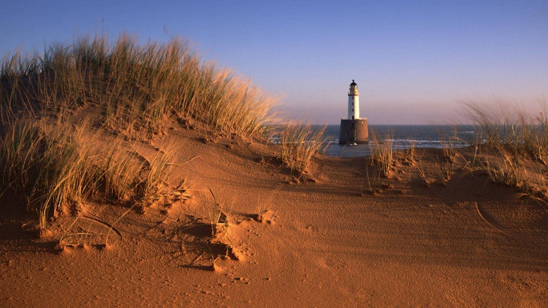 Lighthouse Between Dunes Background