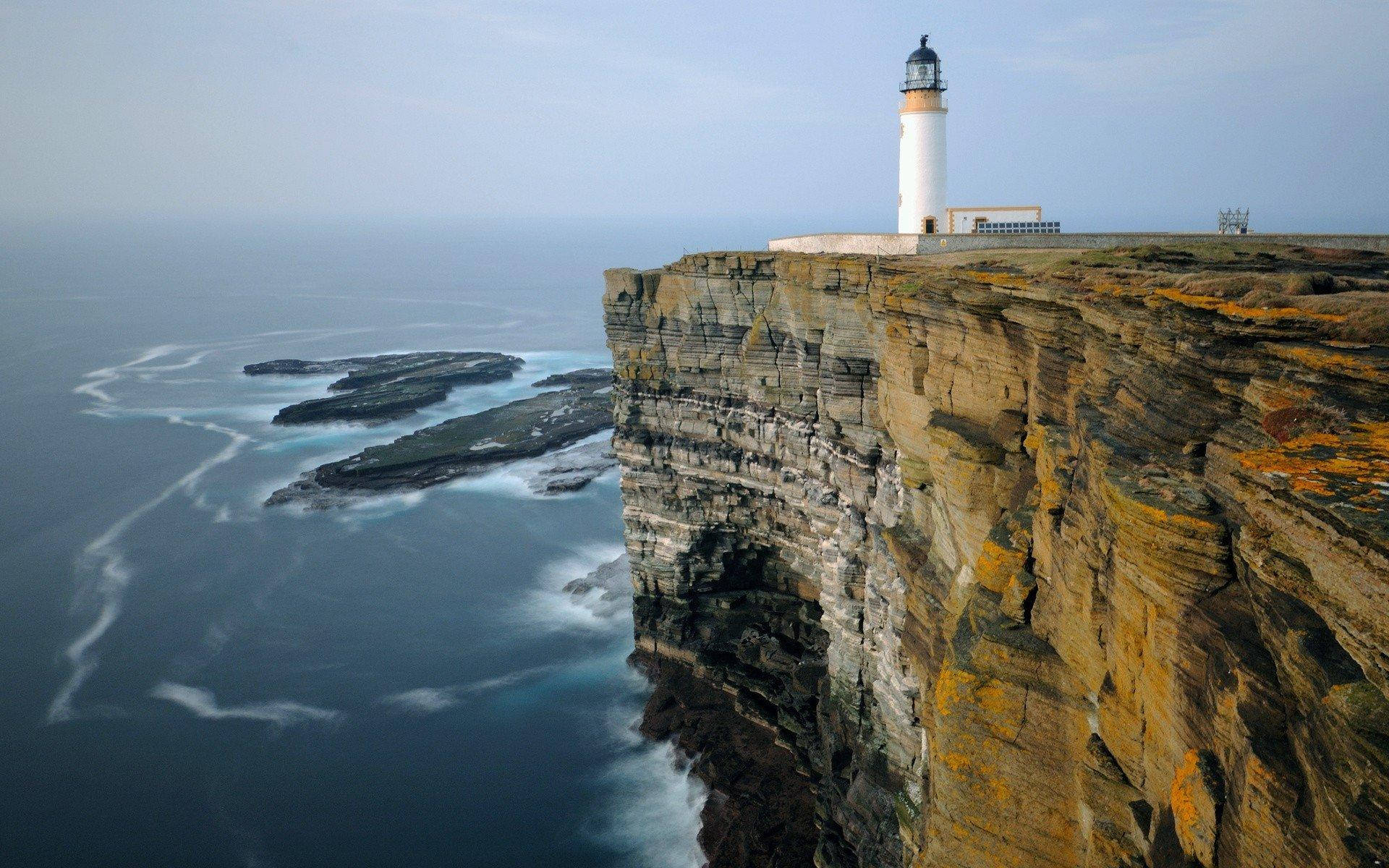 Lighthouse By Ocean Cliff Side Background