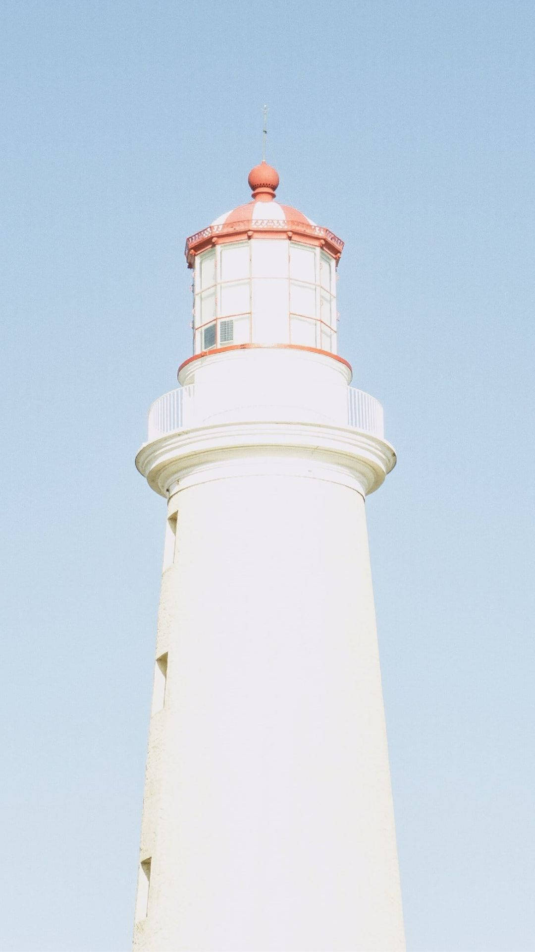 Lighthouse On A Baby Blue Sky Background