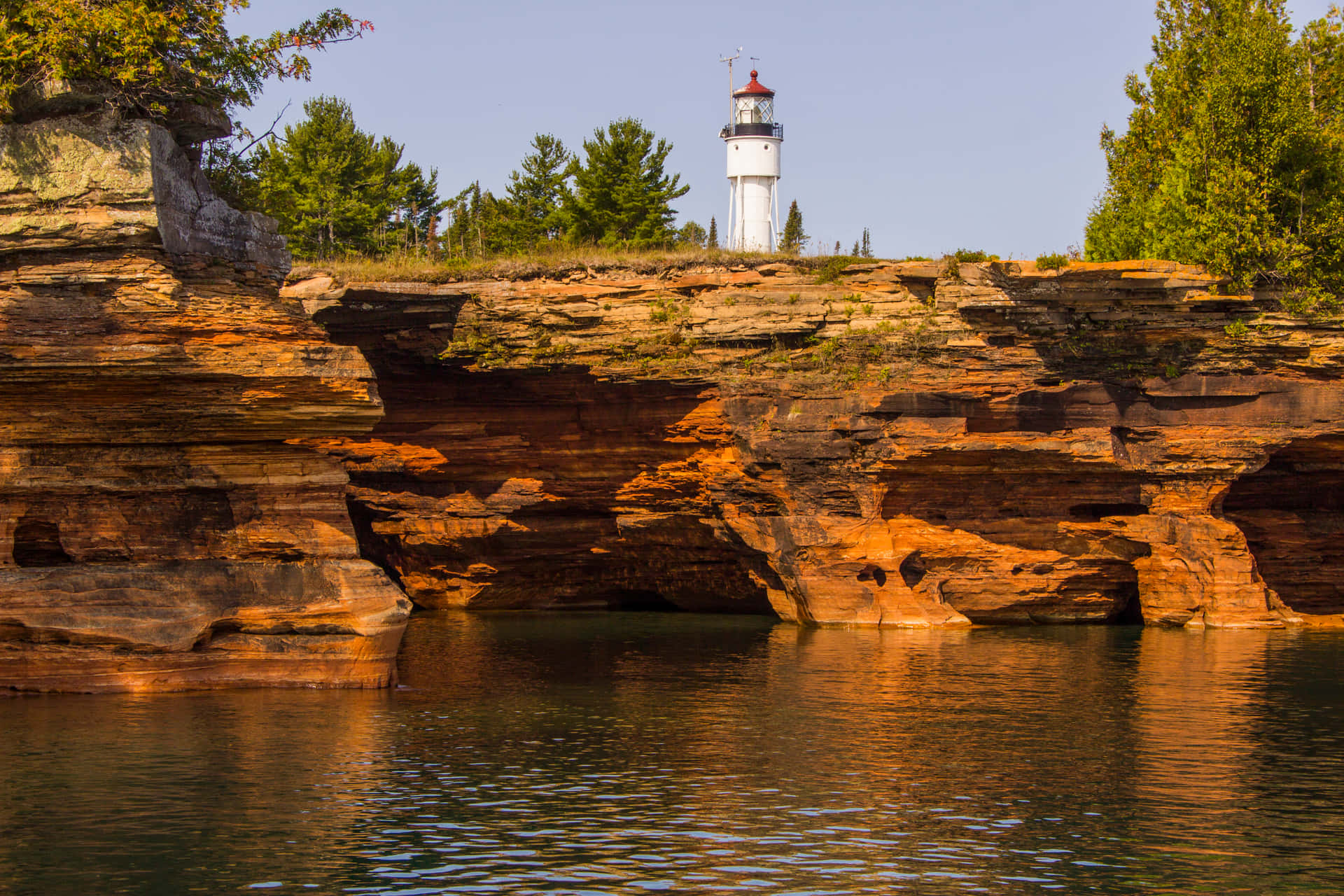 Lighthouse Over Red Rock Formations Background