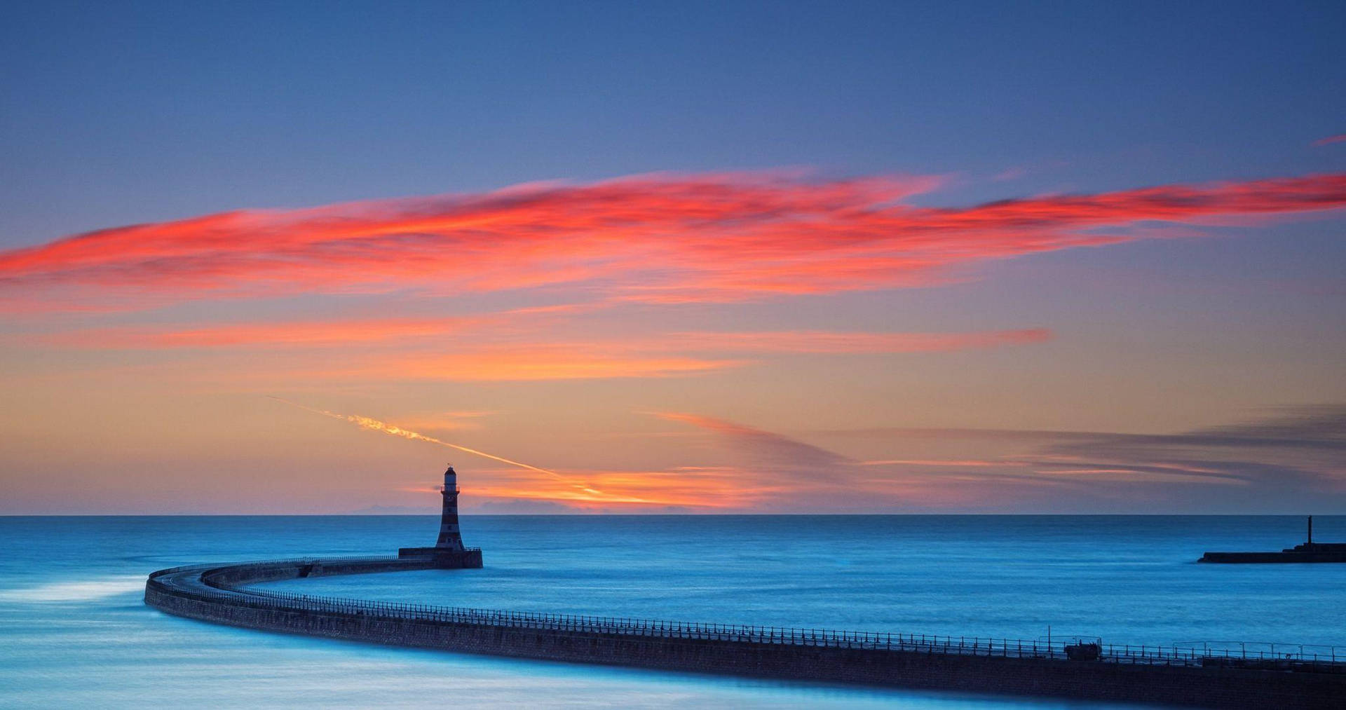 Lighthouse Under Sunset Clouds