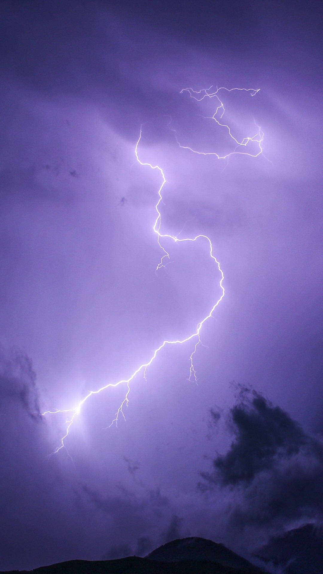 Lightning Strikes Over A Purple Sky With Clouds Background