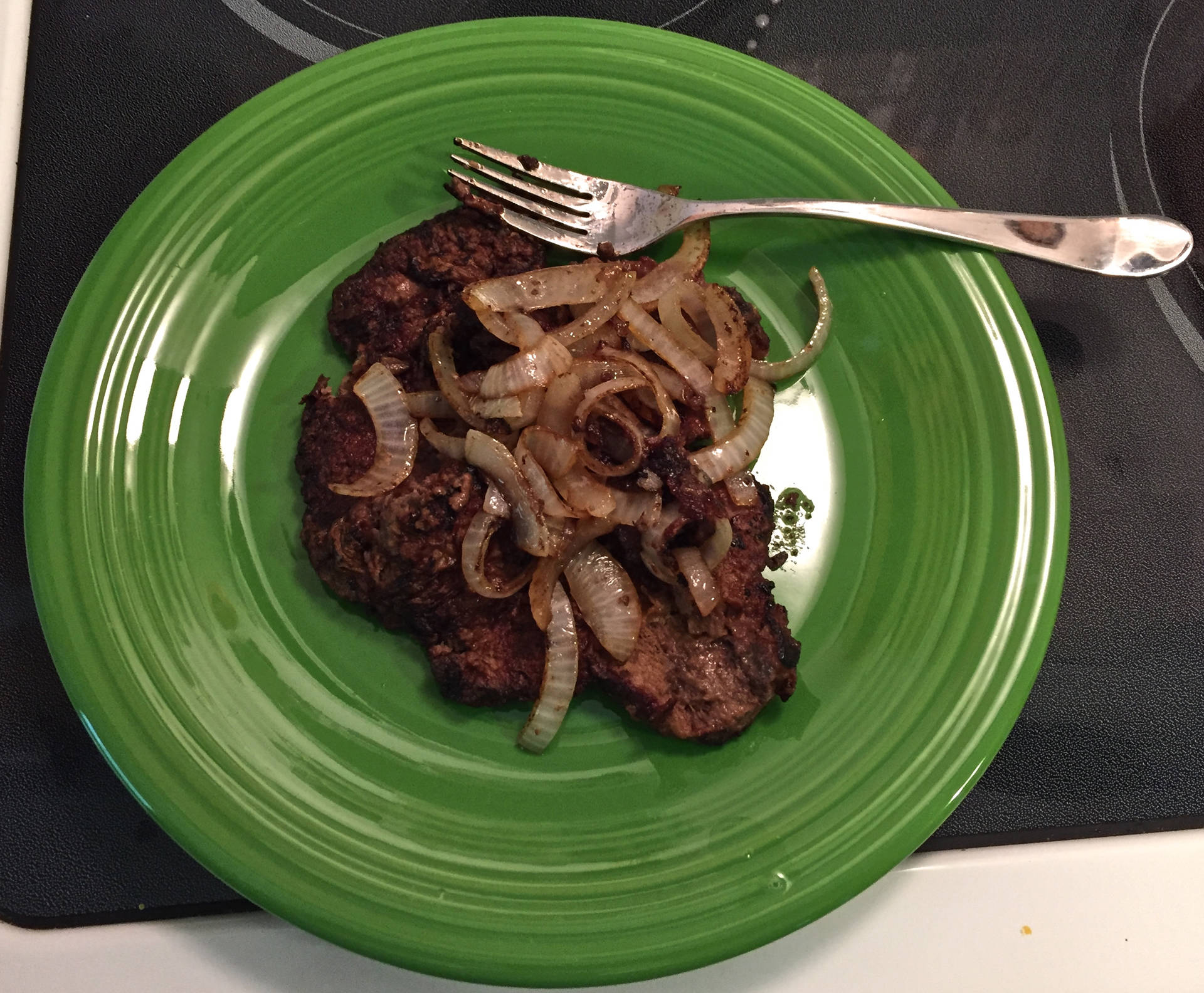 Liver Dinner With Onions On A Green Plate Background