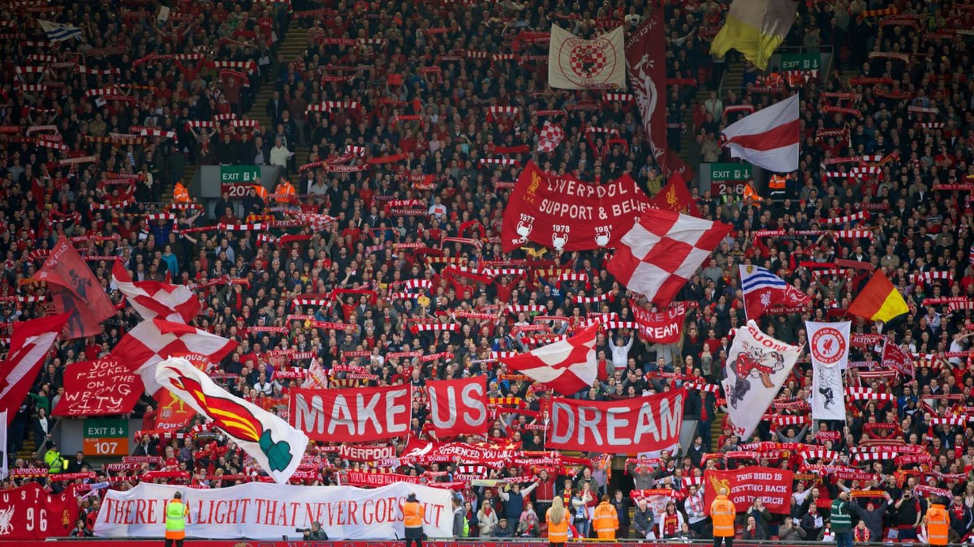 Liverpool Fans In Red And White Holding Flags Background