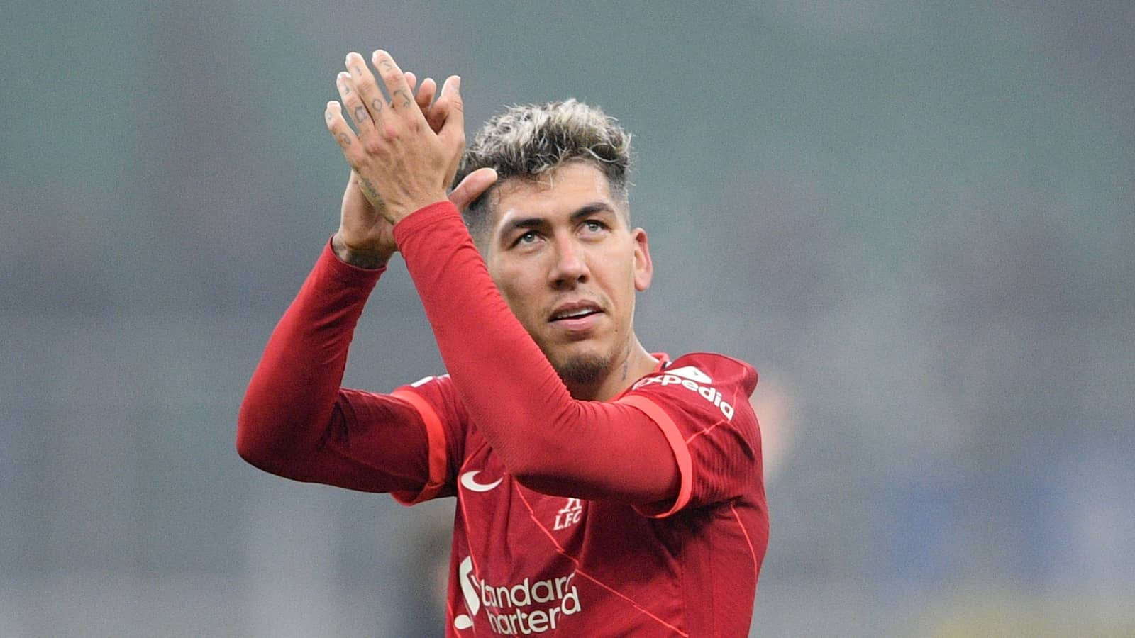 Liverpool Striker Roberto Firmino Applauding On The Pitch Background