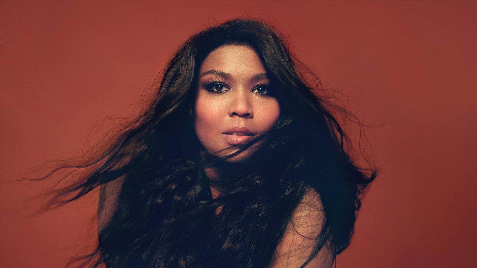 Lizzo In Red Brown Background Background