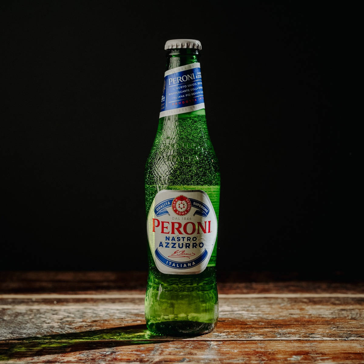 Lone Bottle Of Peroni Beer On A Black Background