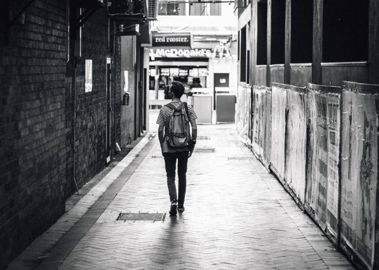Lonely Boy Walking Down An Alley Background