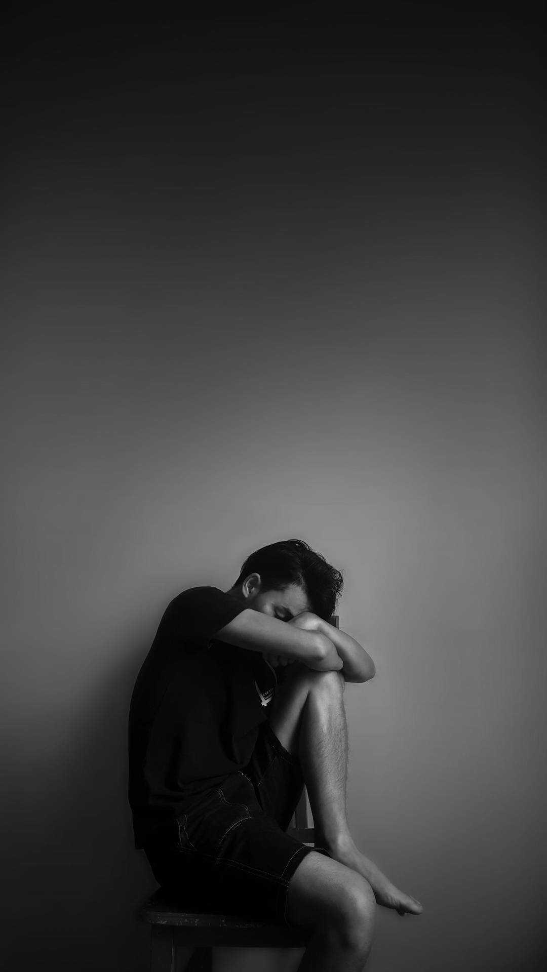 Lonely Man Leaning Against A Wall Background