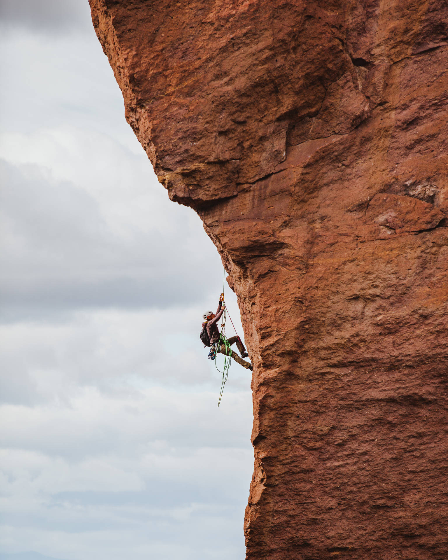 Long Shot Of A Man Rock Climbing Background