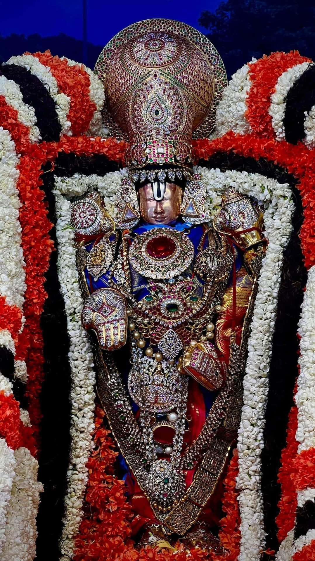 Lord Balaji Adornedin Jewelsand Flowers Background