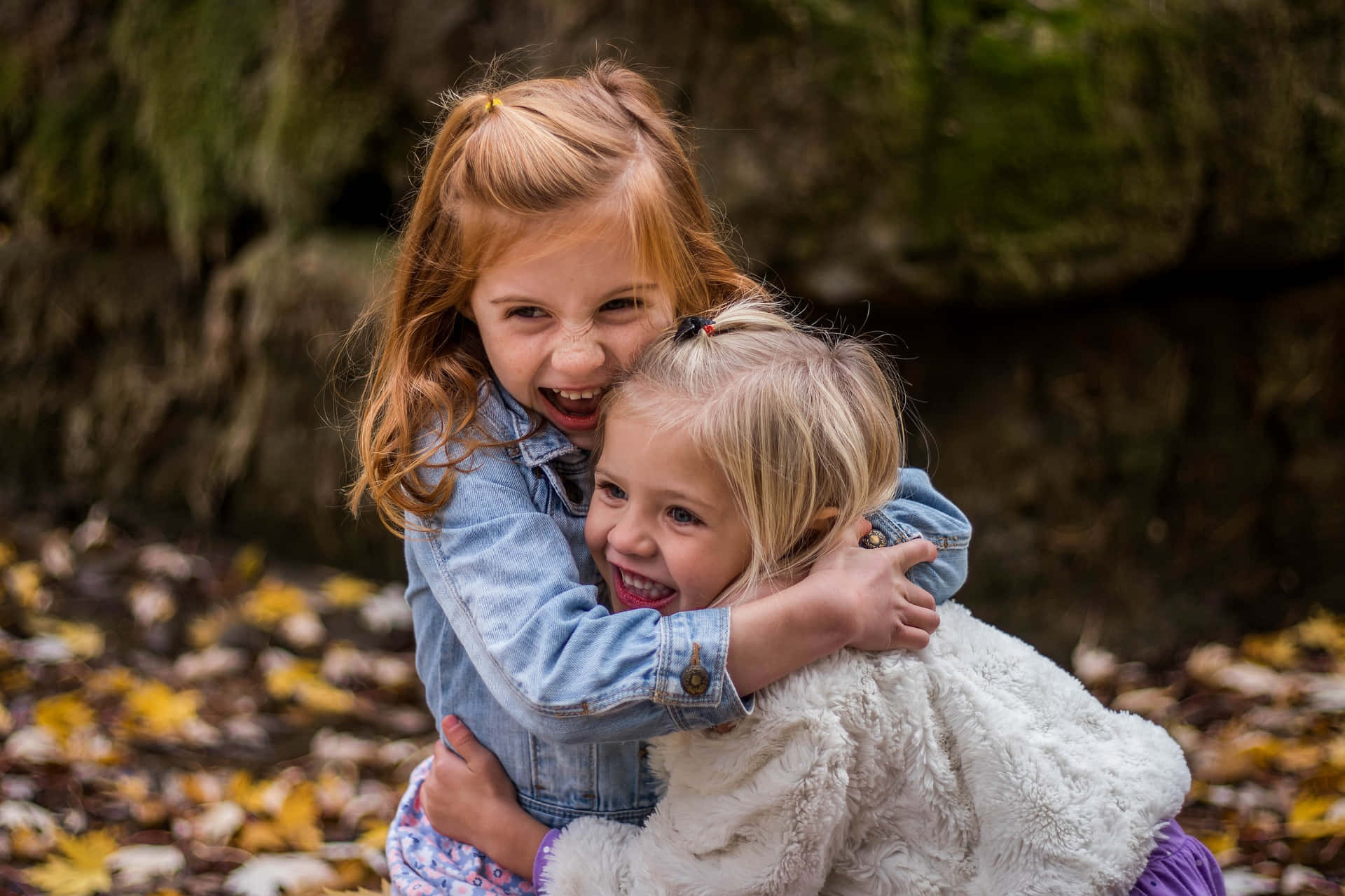 Lovely Picture Of Two Tangible Young Girls Hugging Each Other Background