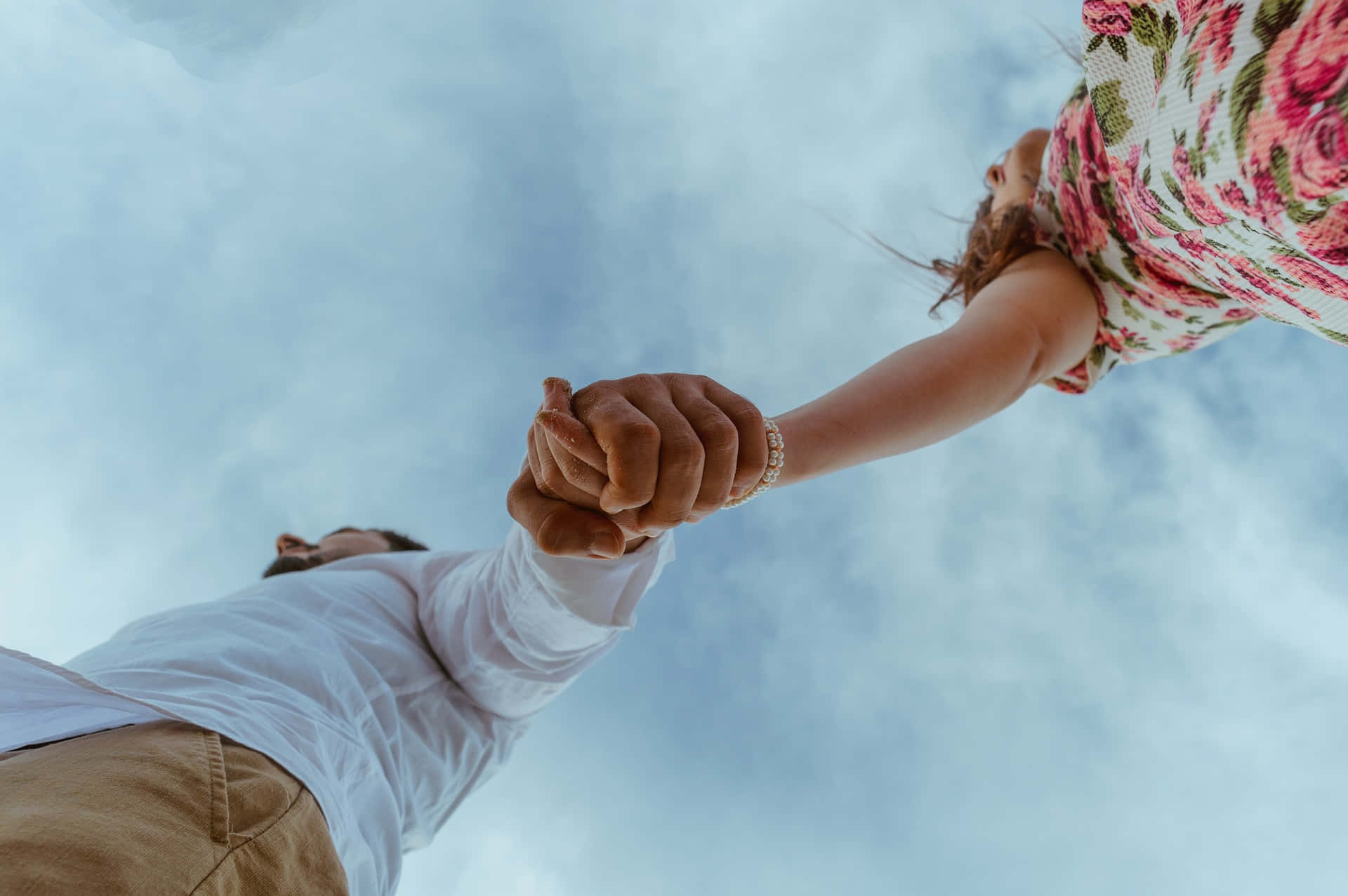 Low Angle Shot Of A Couple Holding Each Other's Tangible Hand Background