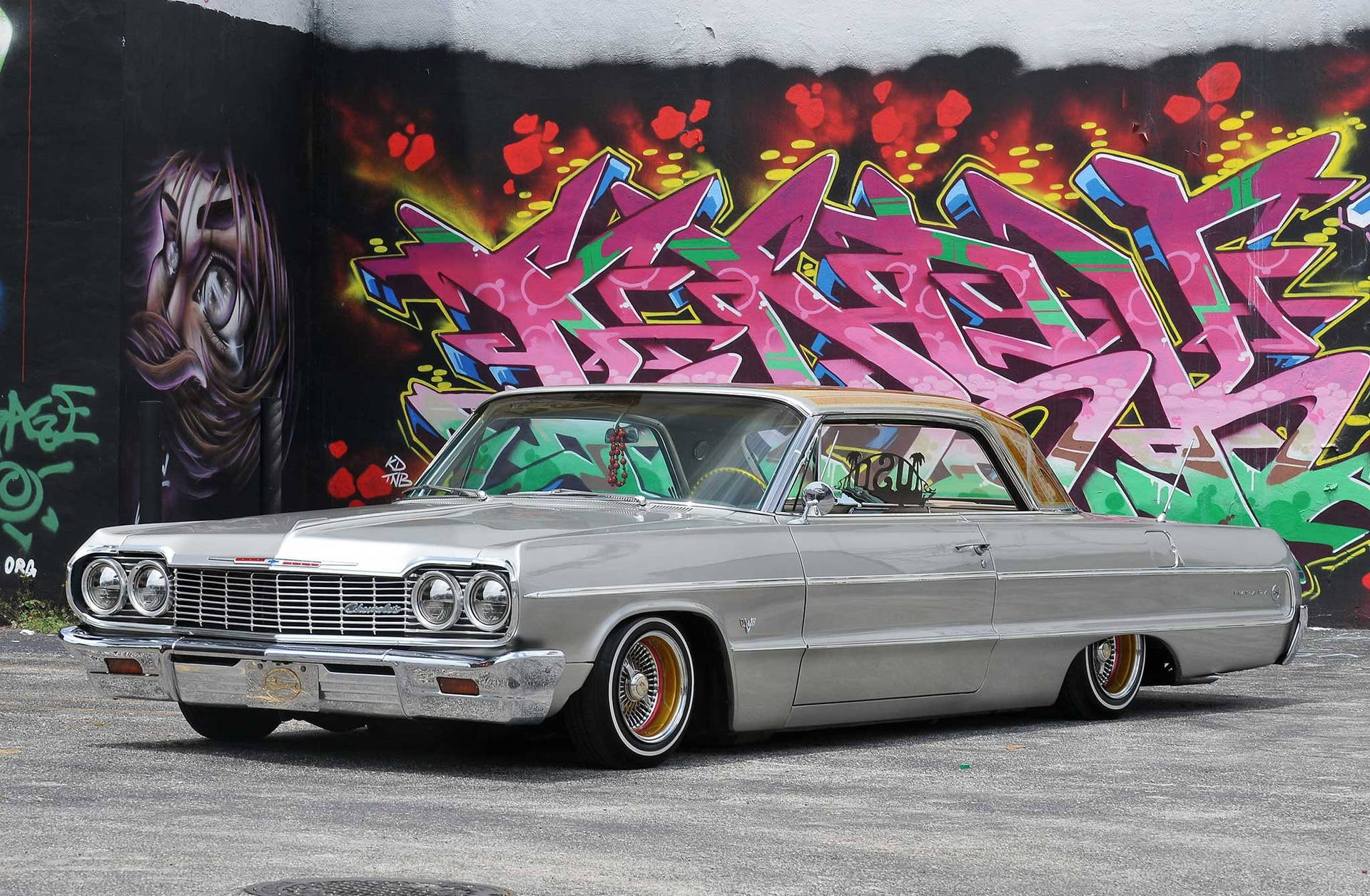 Lowrider Impala Against Colorful Mural Background